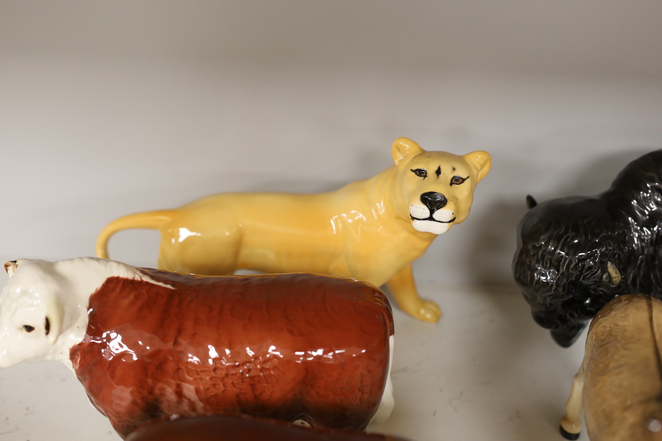 A selection of Beswick animals, to include four bulls and two calves, stag, deer, fawn, fox, panda, falcon, donkey, foal, lioness, lion, and a lion cub (17)